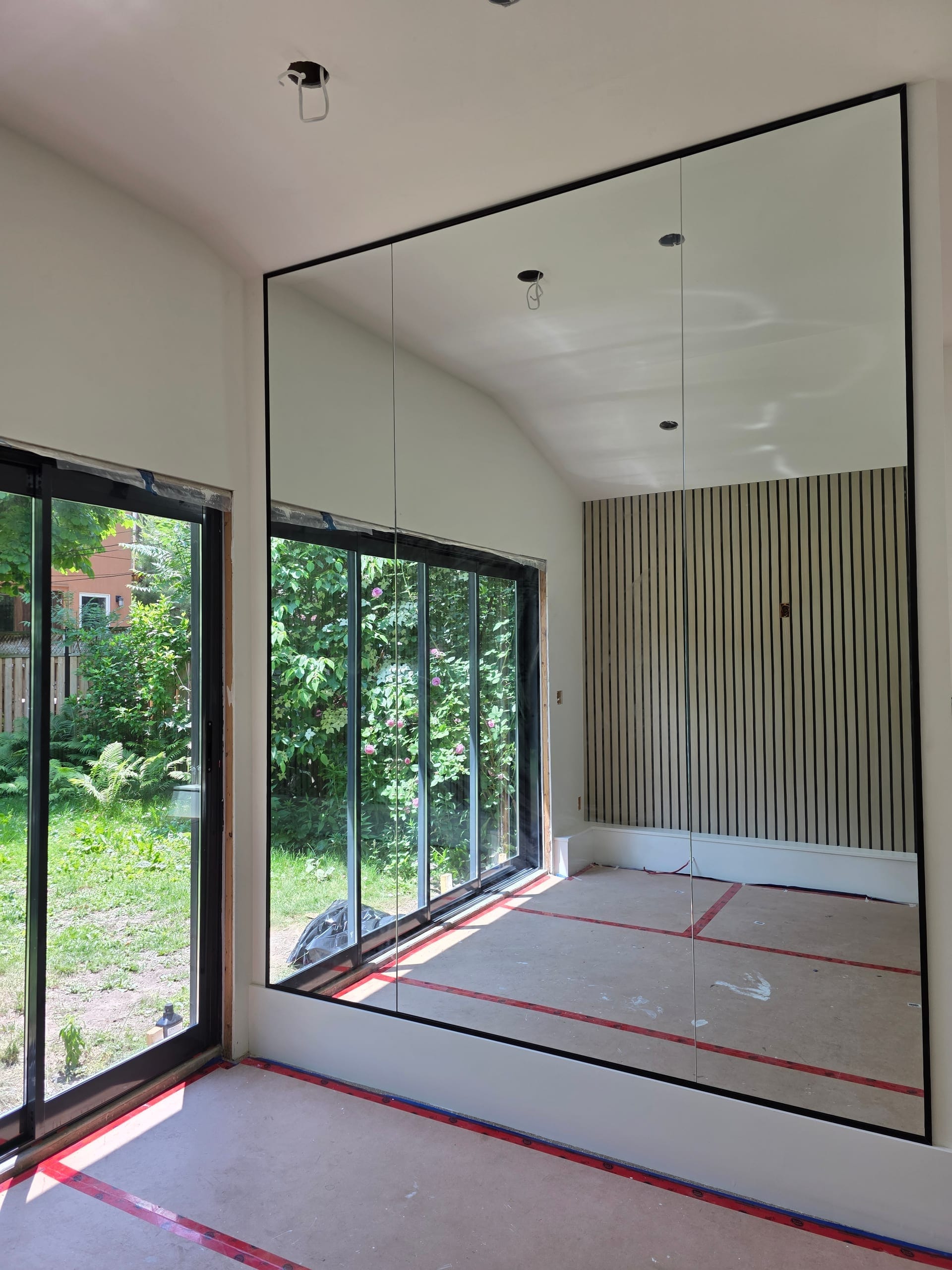 Large frameless wall-to-wall mirror installation in new construction home with floor-to-ceiling windows — Built By Glass GTA