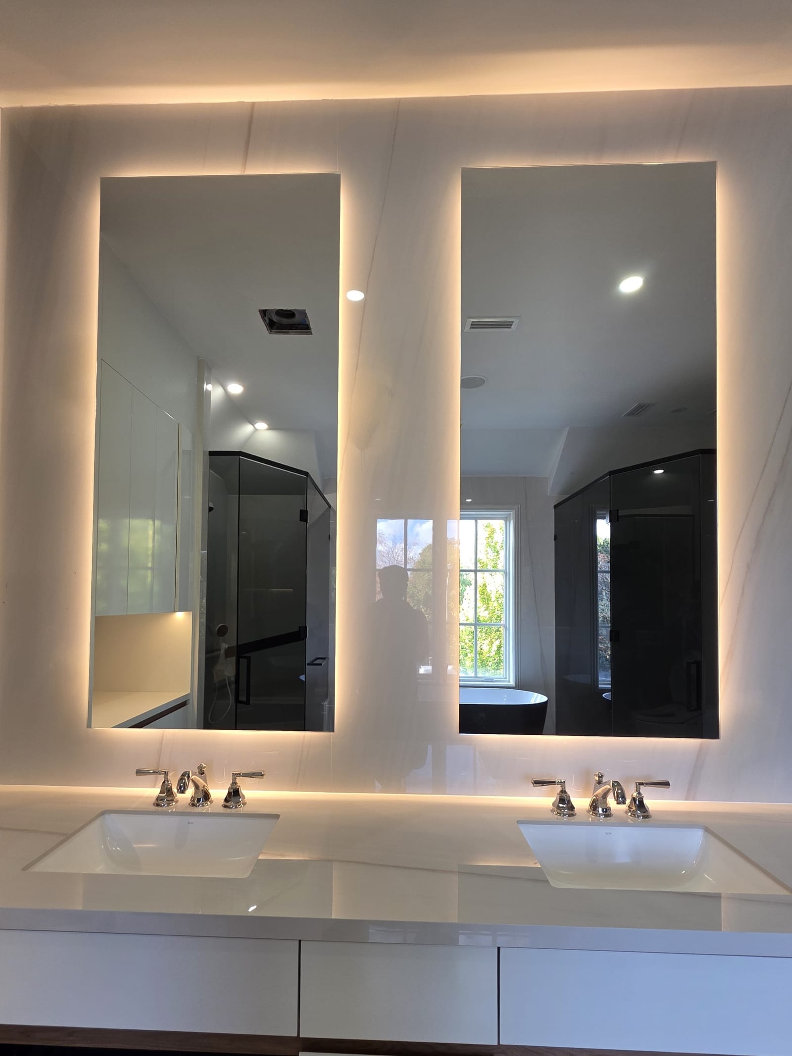 Backlit LED vanity mirrors in a luxury bathroom — Built By Glass
