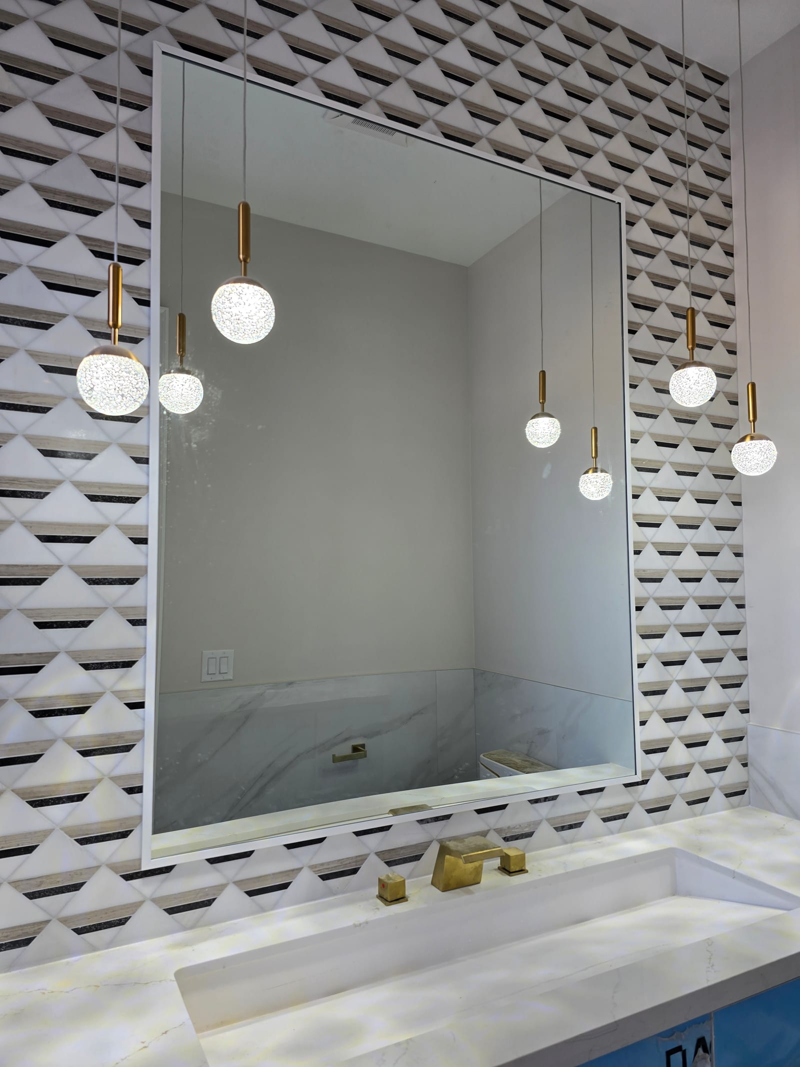 Custom vanity mirror over a geometric-tile feature wall — Built By Glass
