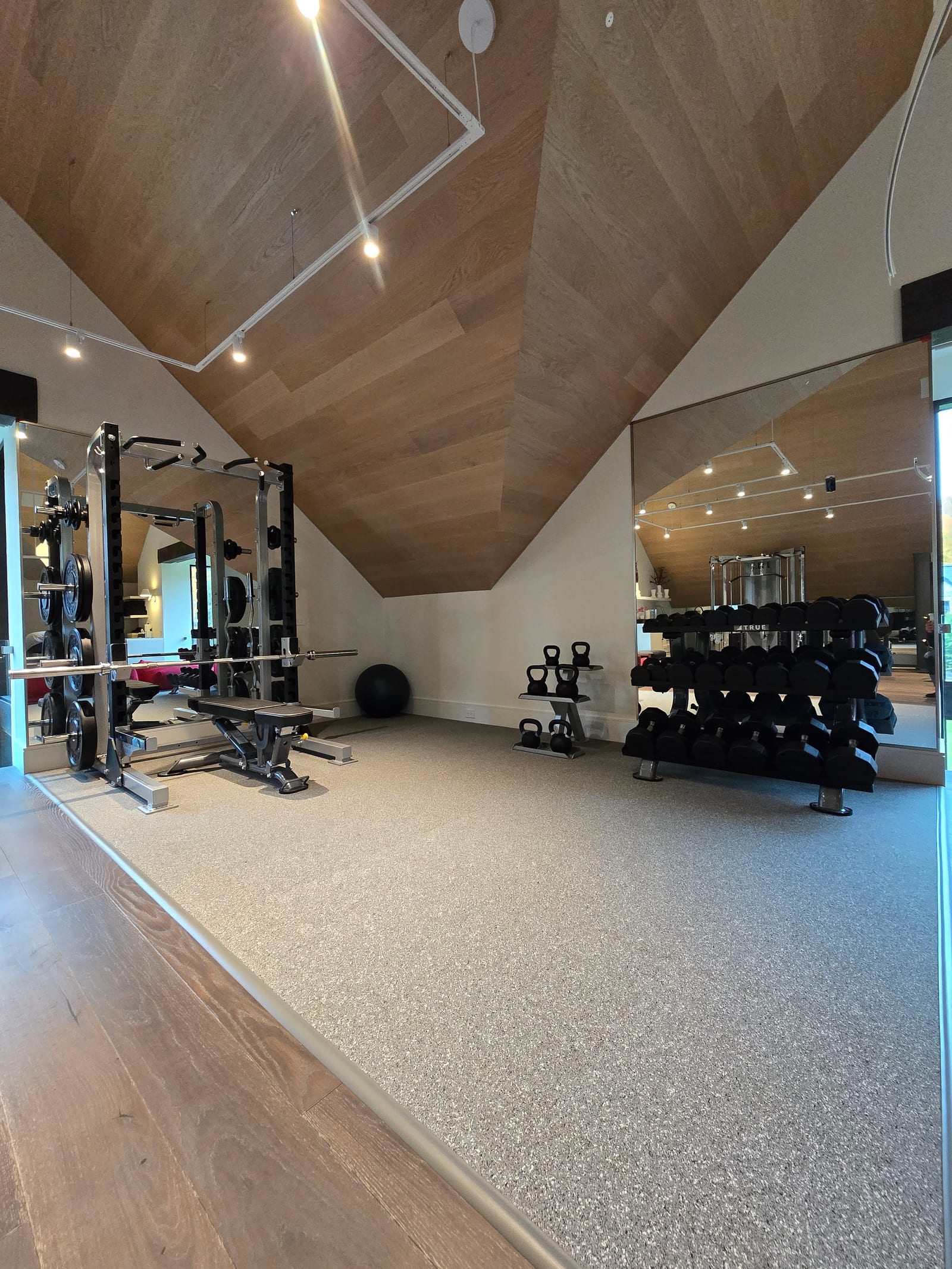 Custom-cut gym mirror wall on a sloped ceiling — Built By Glass, Pickering