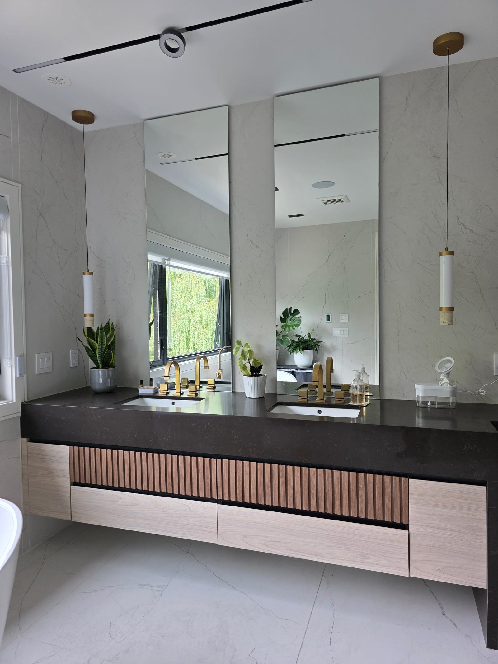 Tall custom vanity mirrors above a floating cabinet — Built By Glass